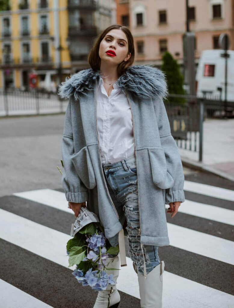 Mujer posando con abrigo oversize azul con cuello de pelo natural de cordero de Mongolia