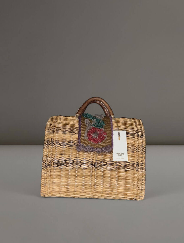 Cesta artesanal Amapola de Yes50 con cierre bordado a mano en tonos rojo, gris y verde.