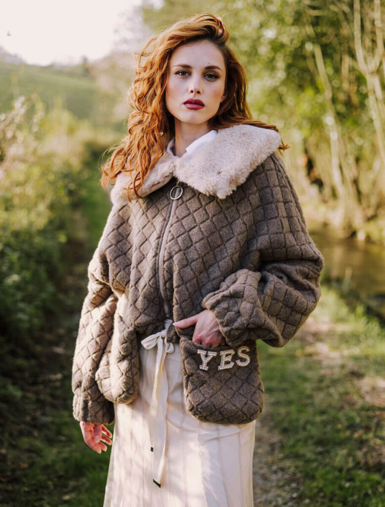 Mujer con cazadora Oscos Piedra de YES50 en entorno natural asturiano.