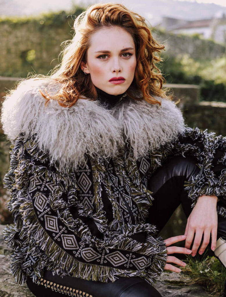 Modelo sentada luciendo la Chaqueta Sama Negra en entorno natural.