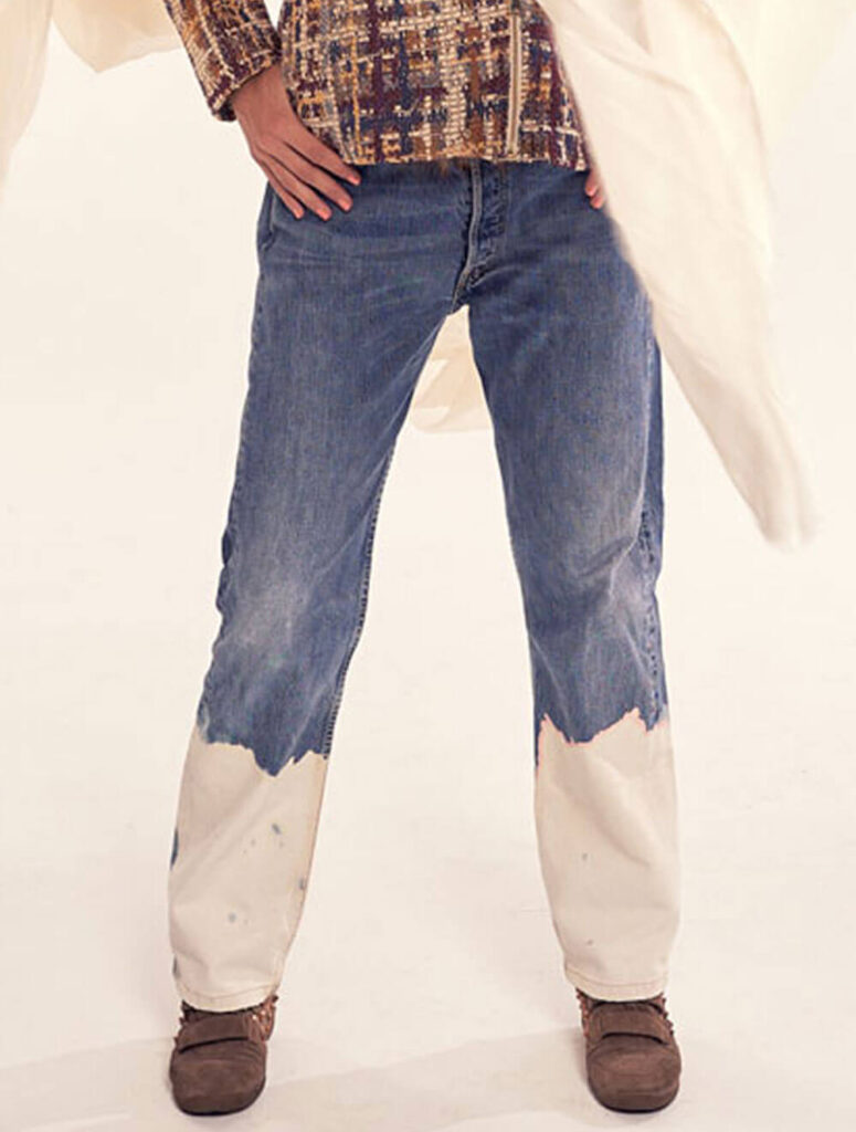 Detalle de vaqueros customizados con efecto pintura blanca en los bajos