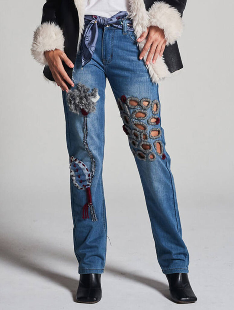 Primer plano de vaqueros customizados con aplicaciones de lana y detalles bordados